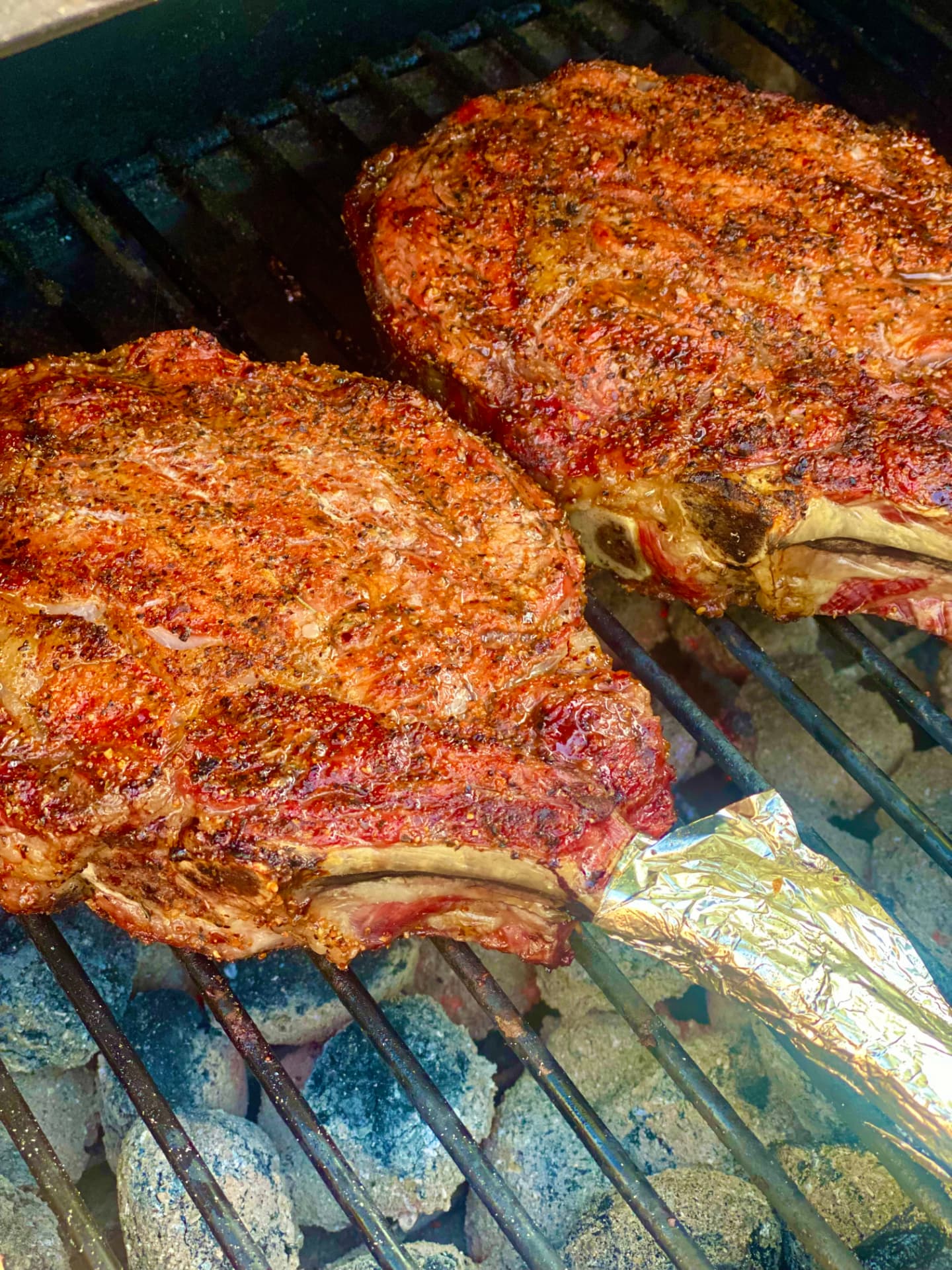Bone-in steaks searing over a fire