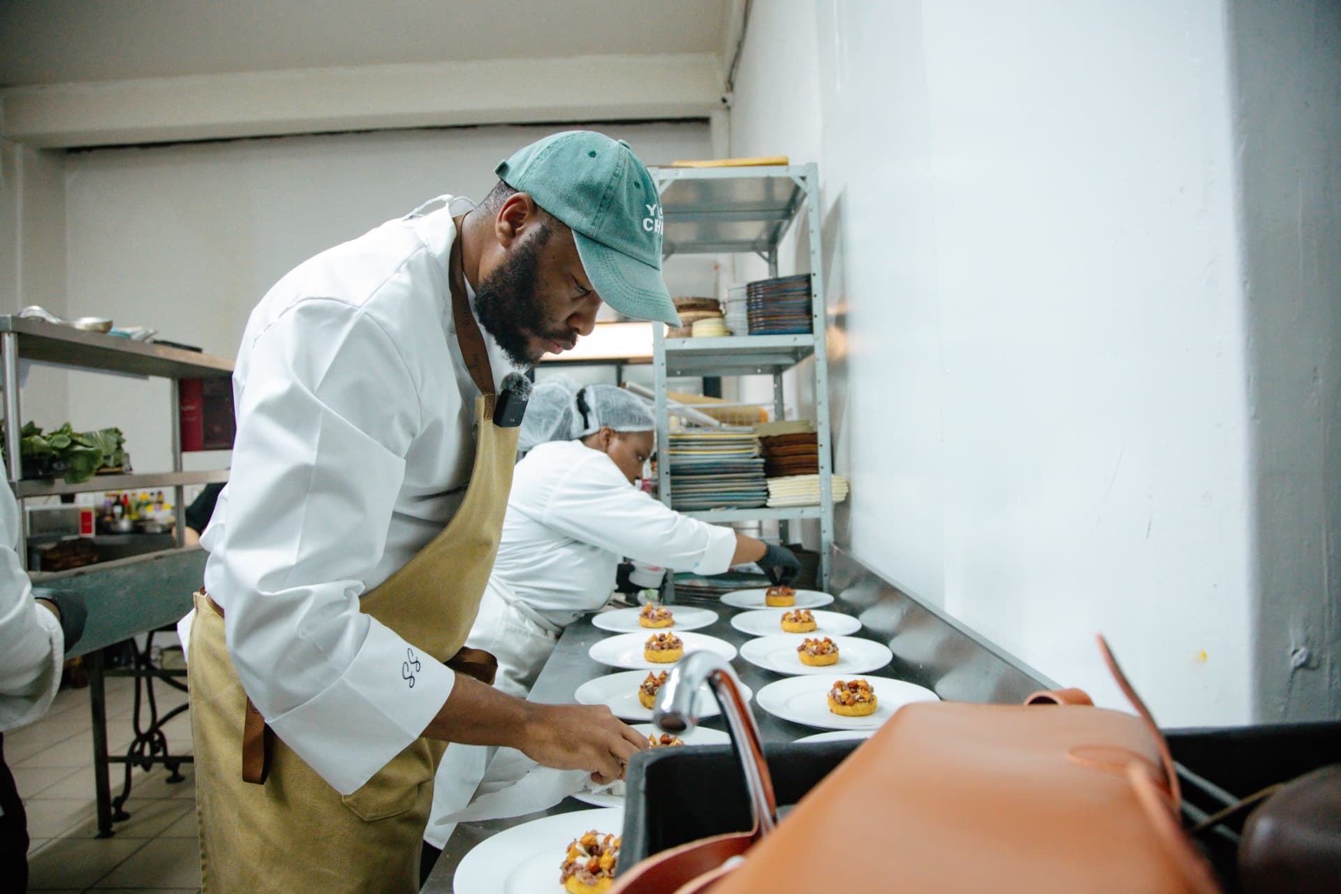 Chef Simele Shange plating dishes in the Braai Society kitchen